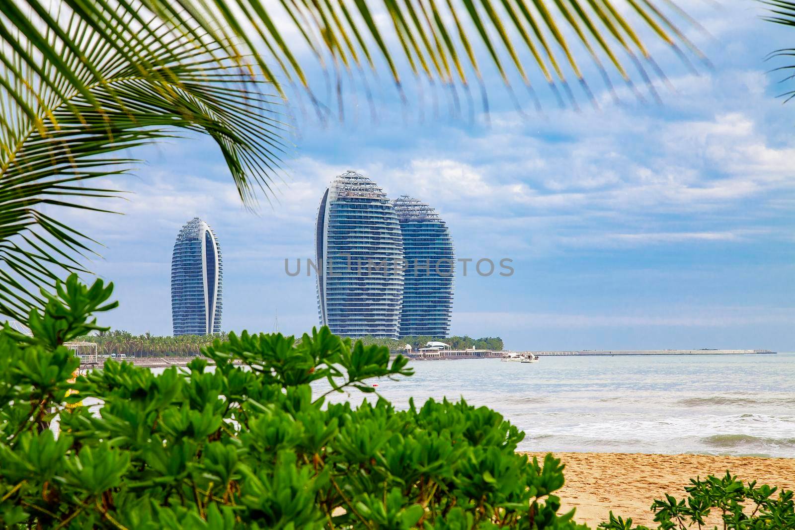 Travel tropical coastline lanscape with sea, foliage and palm leaves