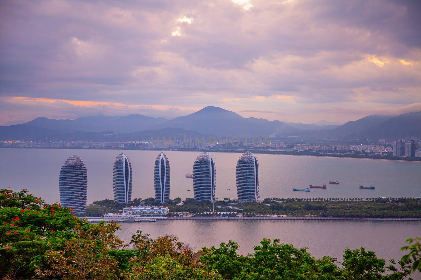 Evening skyscrapers on the sea bay with blue clouds