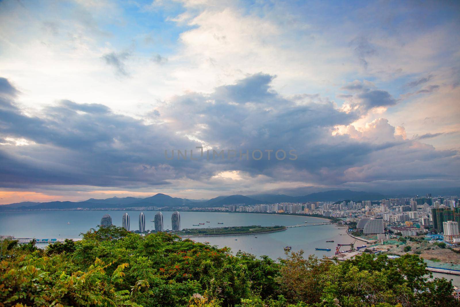 Evening skyscrapers on the sea bay with blue clouds