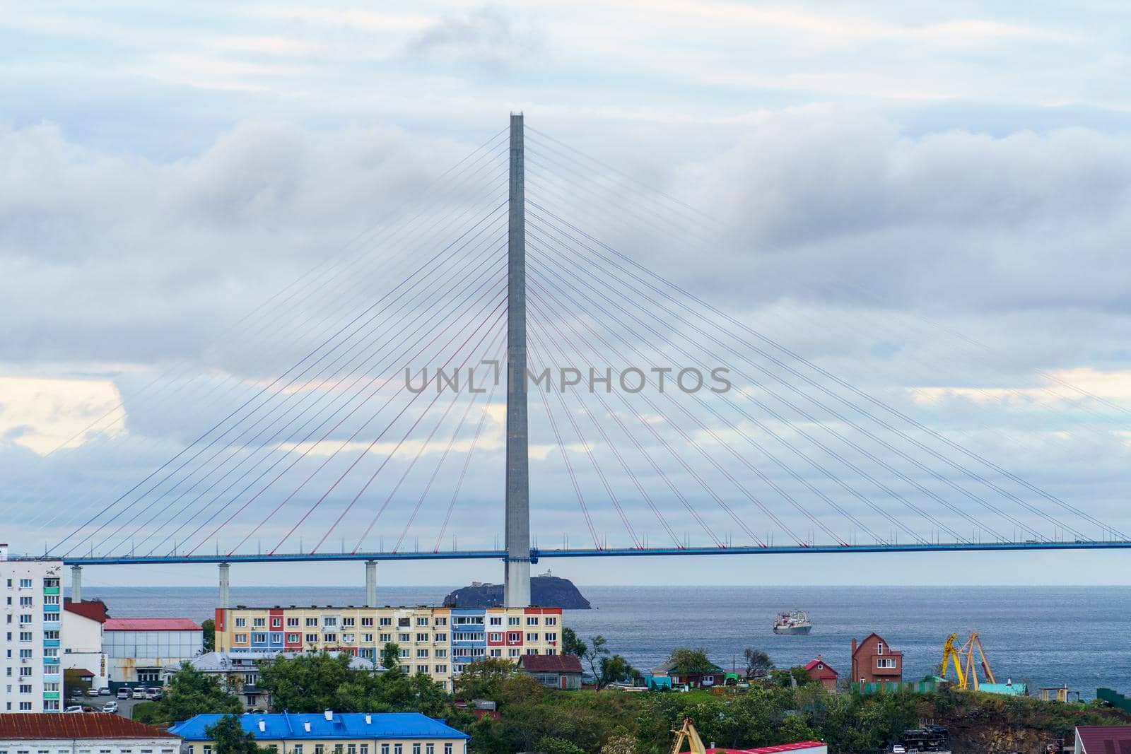 Pylons of the Russian Bridge against the background of the sea and the city. Vladiovtsok, Russia