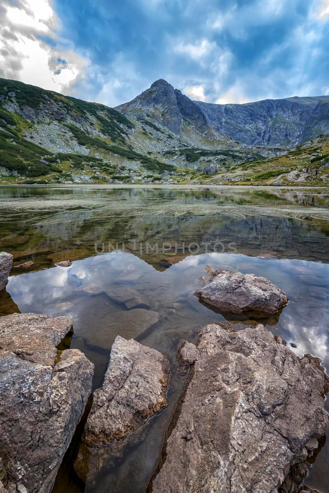 beauty day landscape on the mountain lake with rocks at the front. Vertical view by EdVal