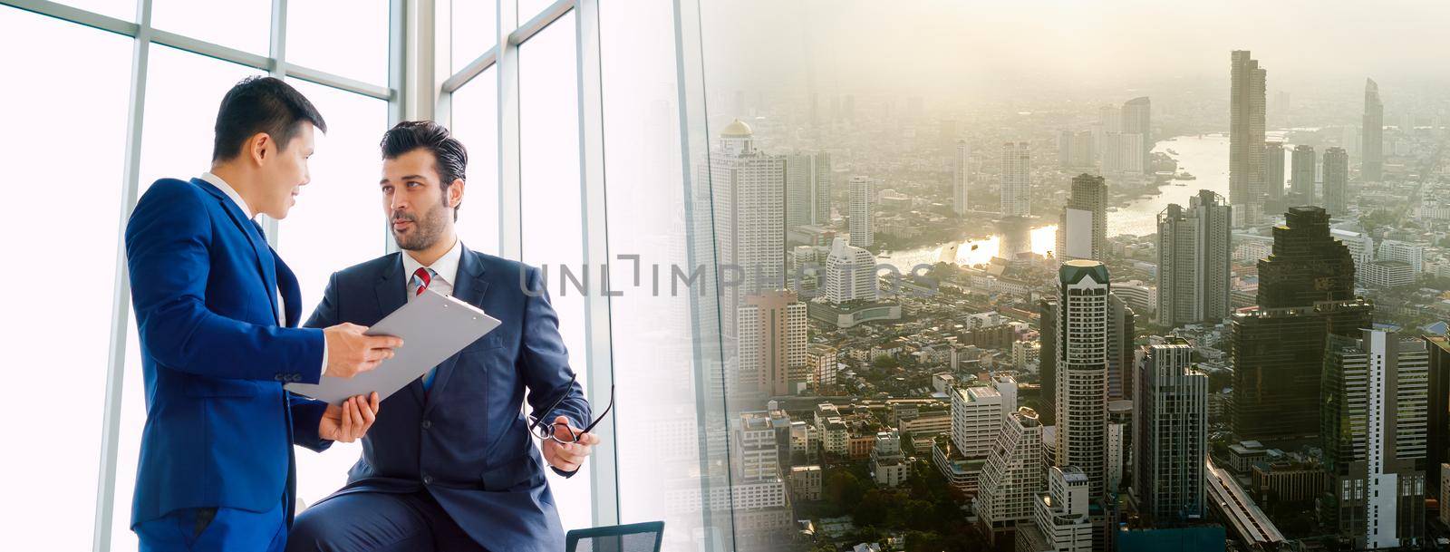 Two business people talk project strategy at office in widen view meeting room. Businessman discuss project planning with colleague at modern workplace .