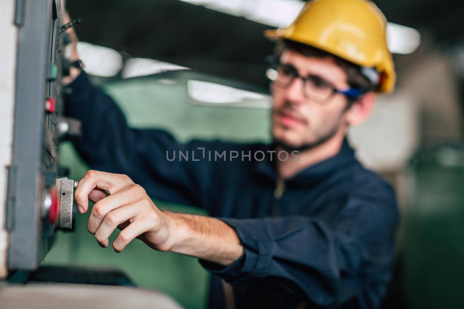 young profession technician engineer operate heavy machine to automated CNC in factory, close-up worker hand. by qualitystocks