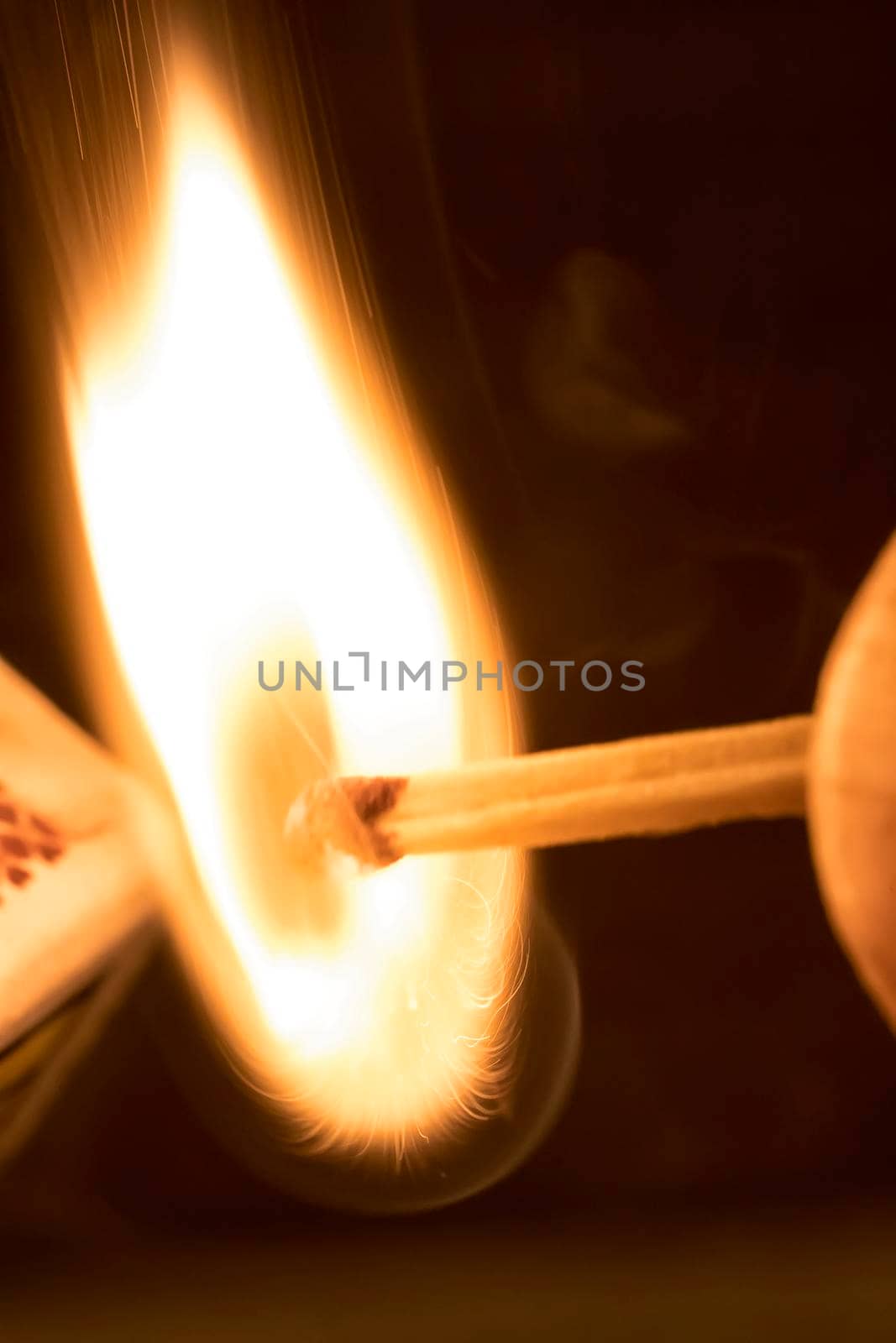 Close-up view to strike matches for matchbox. Detail of ignition matches for matchbox. Macro lighting of a match striking out a matchbox. 