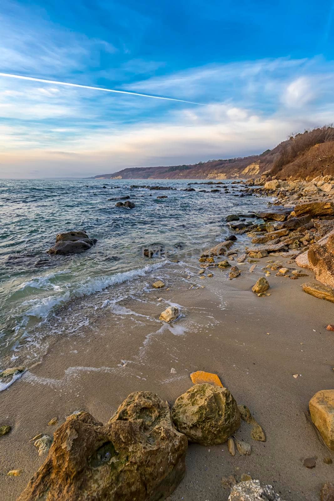 Beautiful vertical view of the coastline with stones on the sand by EdVal