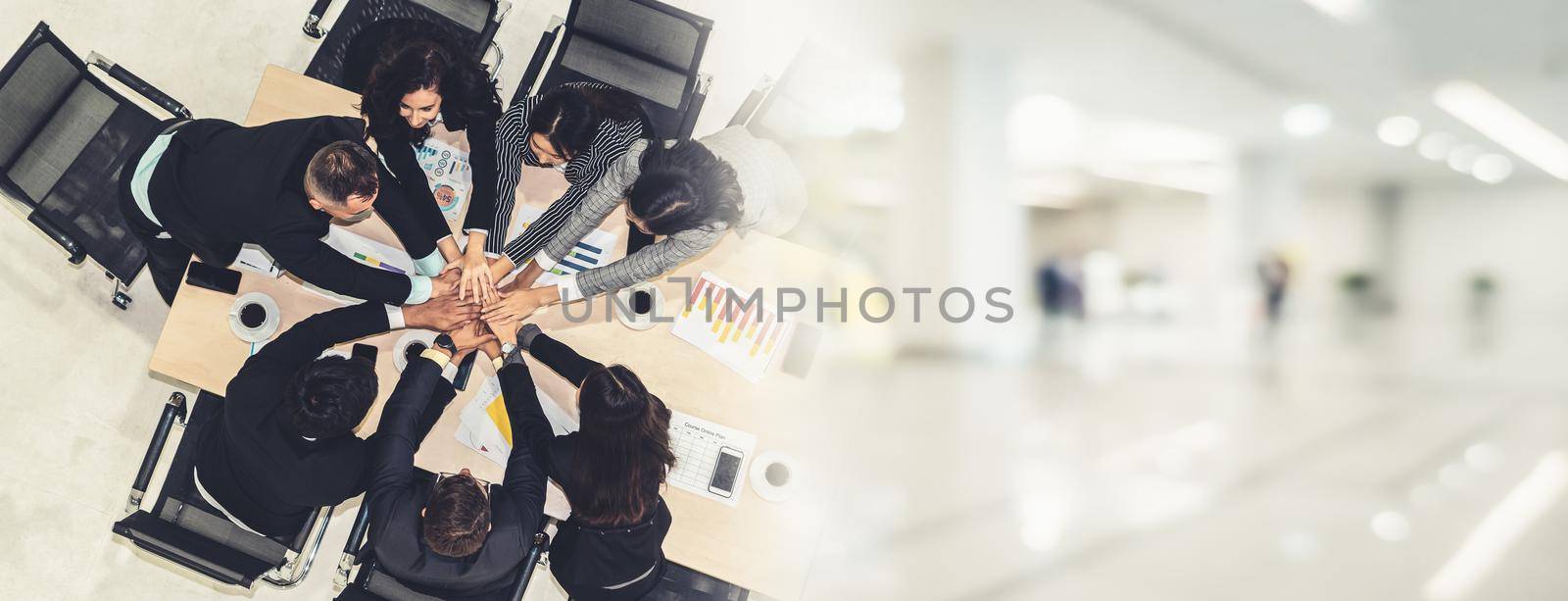 Happy business people celebrate teamwork success together with joy at office table shot from top view . Young businessman and businesswoman workers express cheerful victory in broaden view .