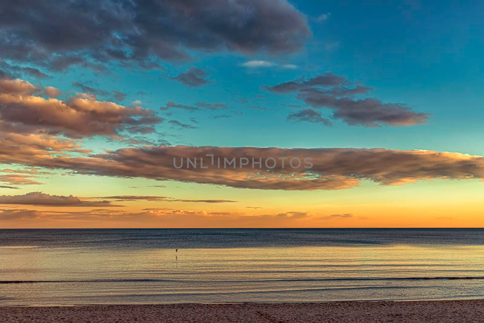 Beautiful colorful clouds over the sea. Amazing sky after sunset.