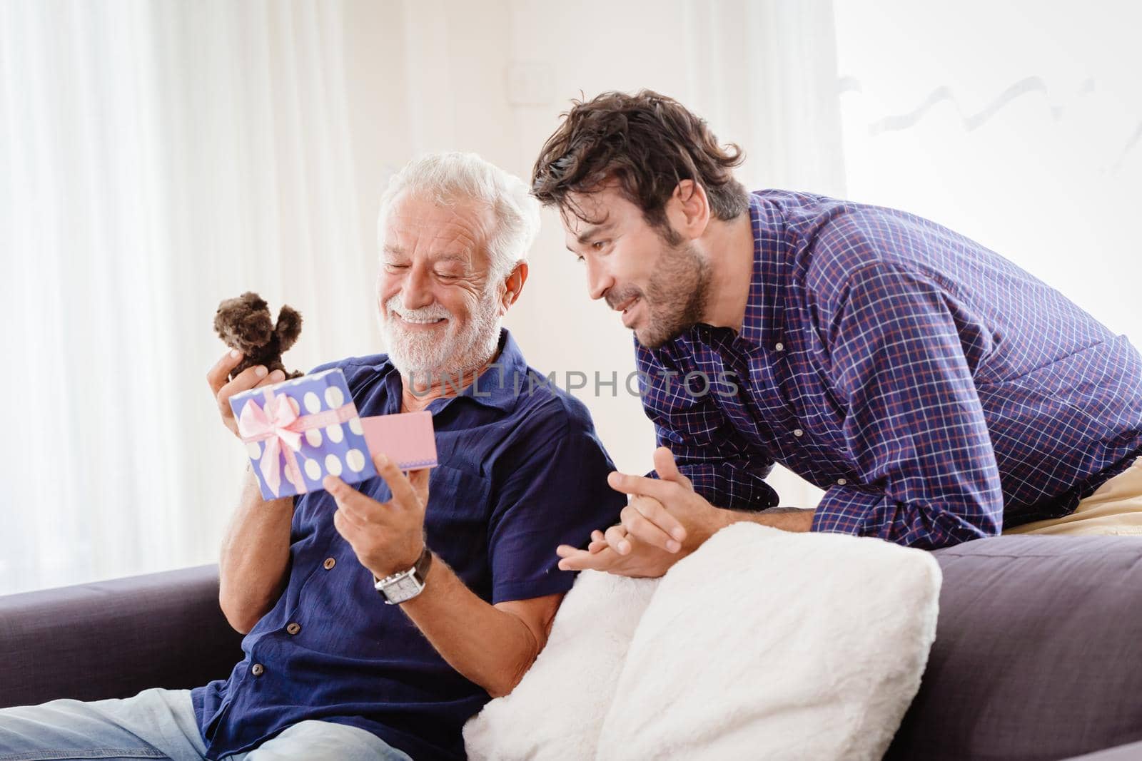 young man returned family home during the New Year's holiday with a cute gift box to the old man, Elder smiled and was very happy with teddy present.
