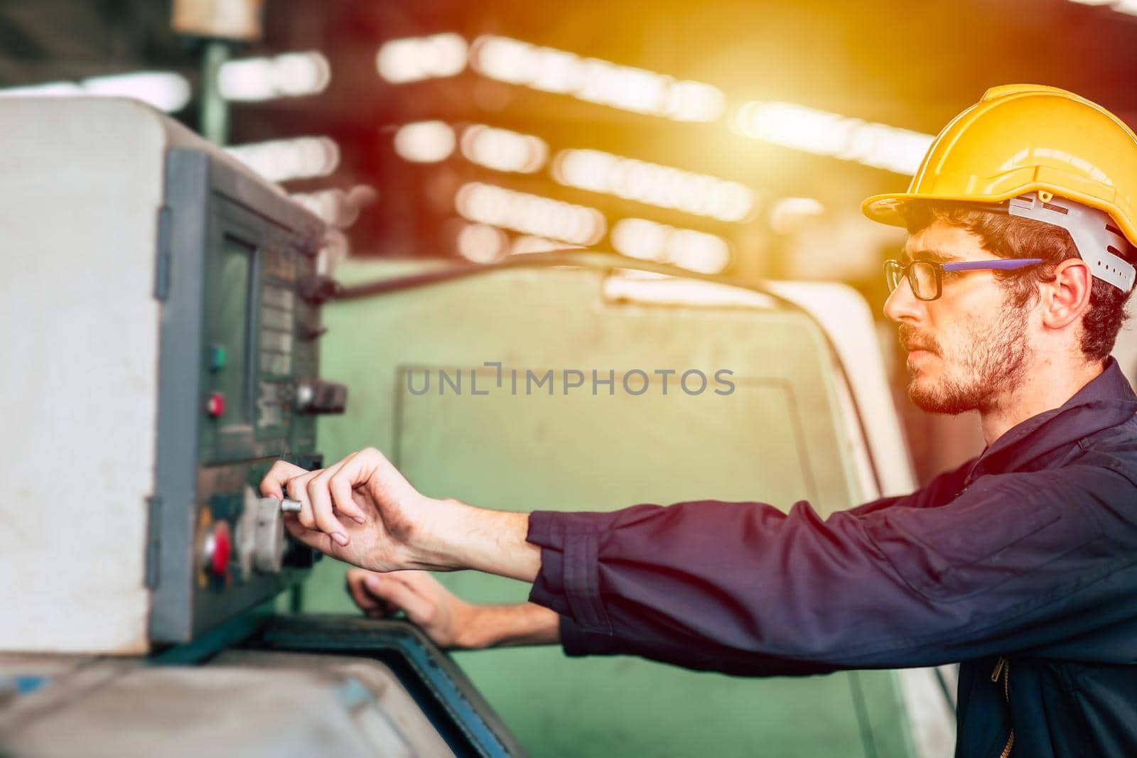 Young professional technician engineer operate the machine to automated CNC in heavy industrial factory.