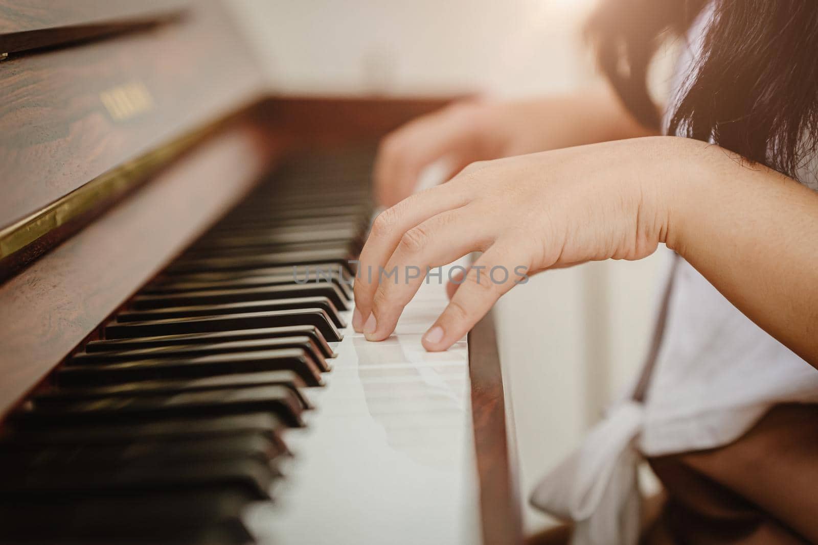 Closeup woman hand playing piano at home vintage colortone.