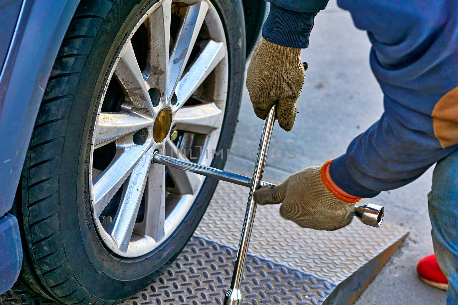 Replacing a car wheel at a tire station. a rubber covering, typically inflated or surrounding an inflated inner tube, placed around a wheel to form a flexible contact with the road