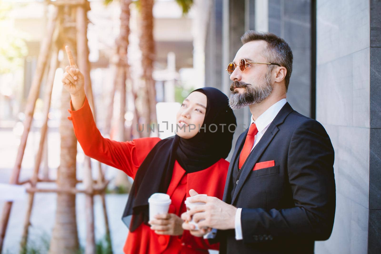 Arab Muslim business people man and woman talking together planning future dream project together hand pointing at high