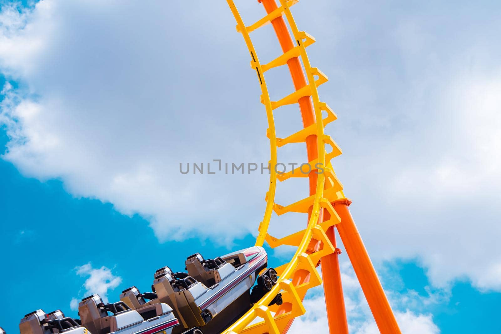 roller coaster high in the summer sky at theme park most excited fun and joyful playing machine by qualitystocks