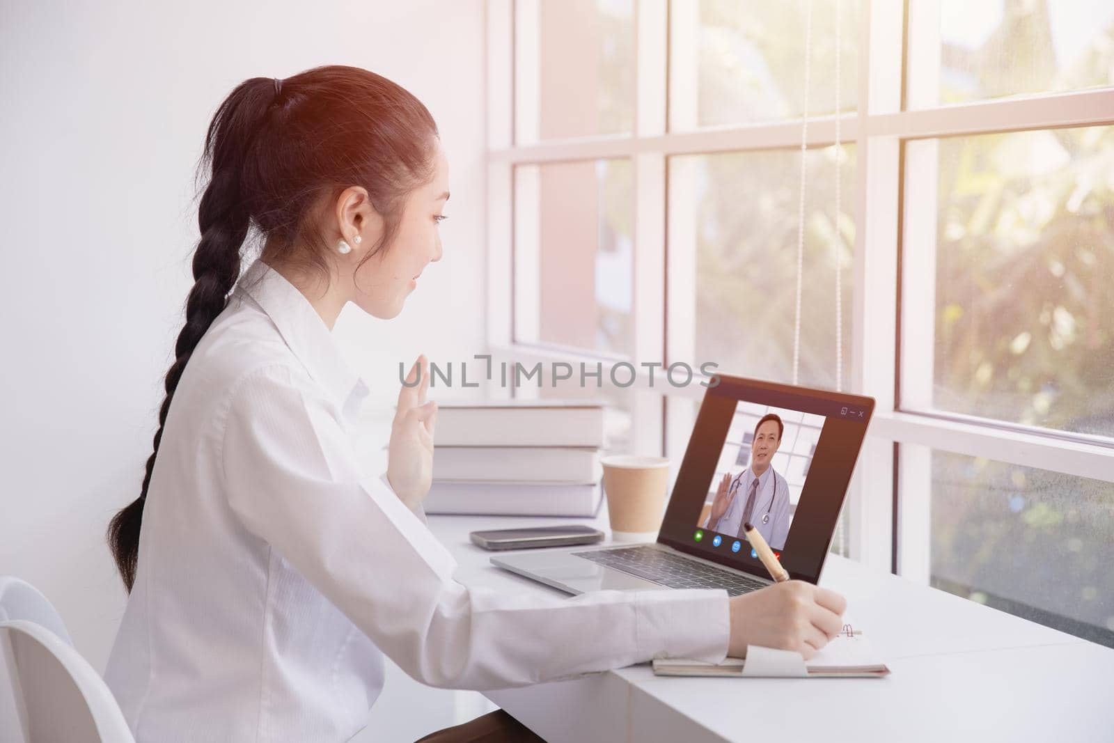 Woman greeting video call with doctor from internet channel staying at home. Girl teen patient in video conferencing with general health practitioner or online personal healthcare for consult. by qualitystocks