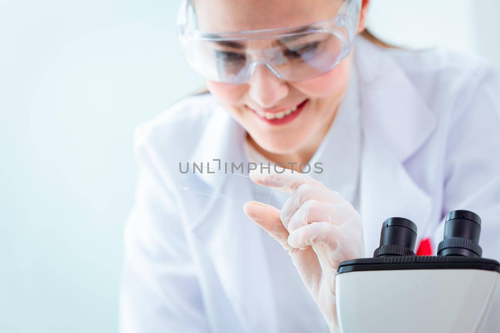 Scientist smiled while holding the test results for the virus vaccine in a science medical research lab.