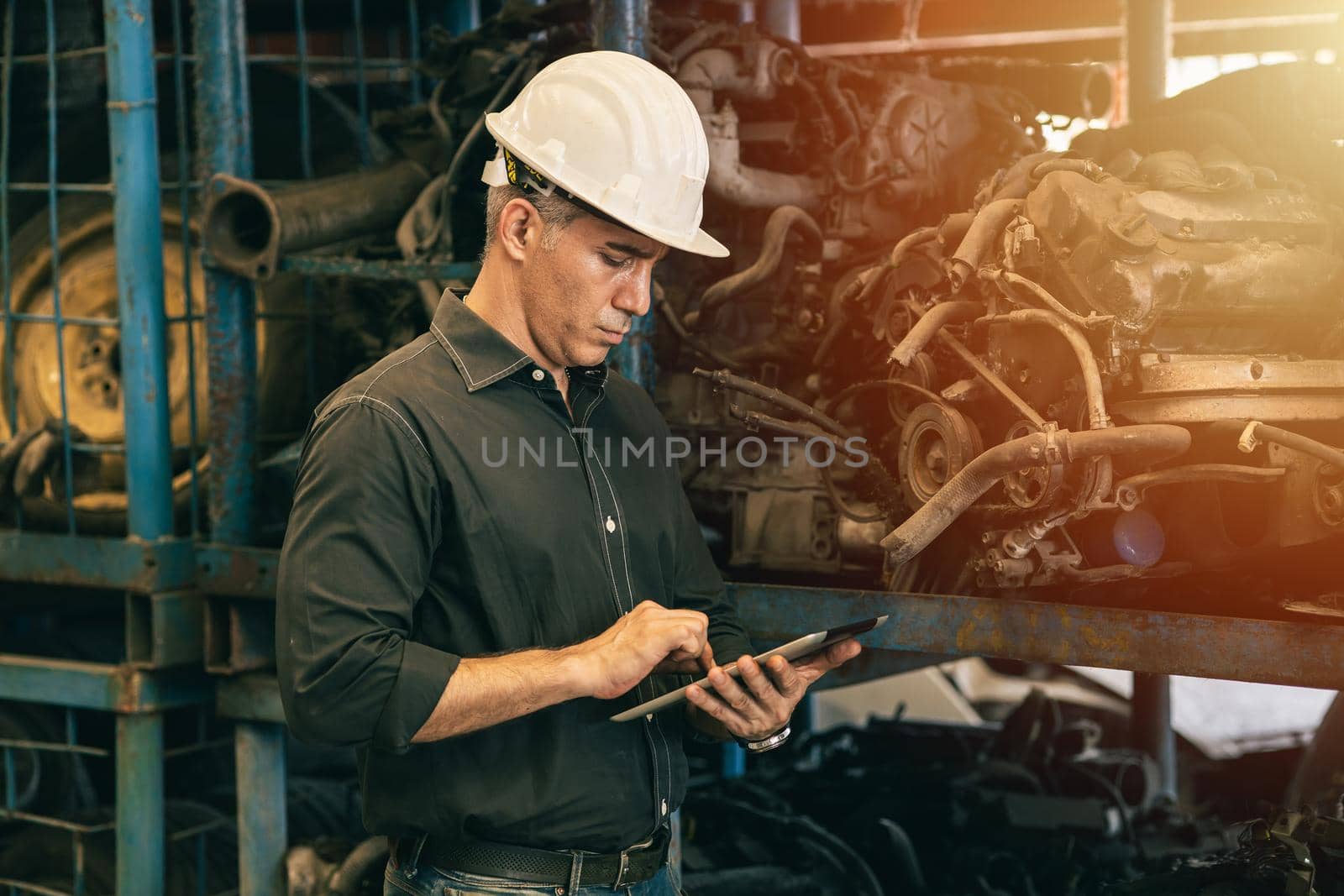 Professional adult Engineer male attending duty work in factory working checking stock inventory data with tablet computer by qualitystocks