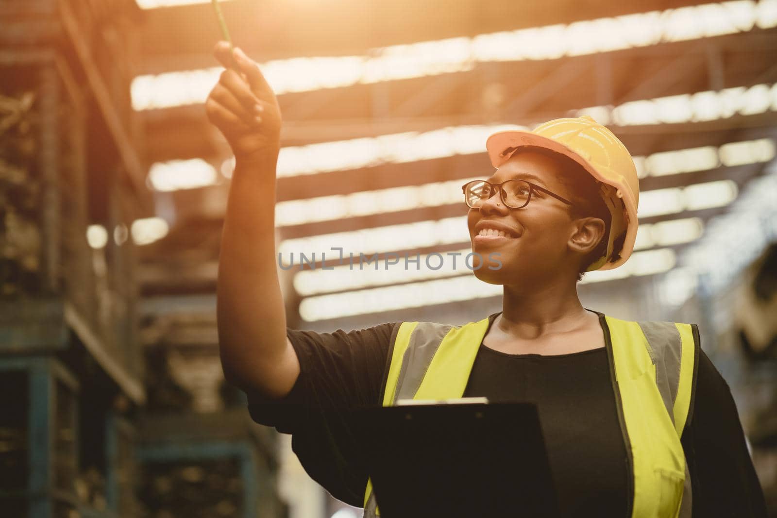 Black African professional women worker happy working count checking inventory production stock control in business factory  industry warehouse waring engineer suit and helmet for safety by qualitystocks