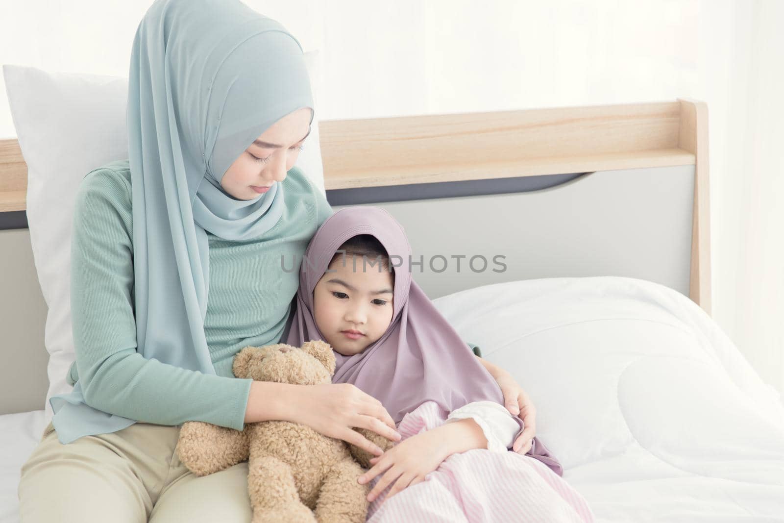 muslim mother consoling cry and depress little child from being bullied and hate to go to school. by qualitystocks