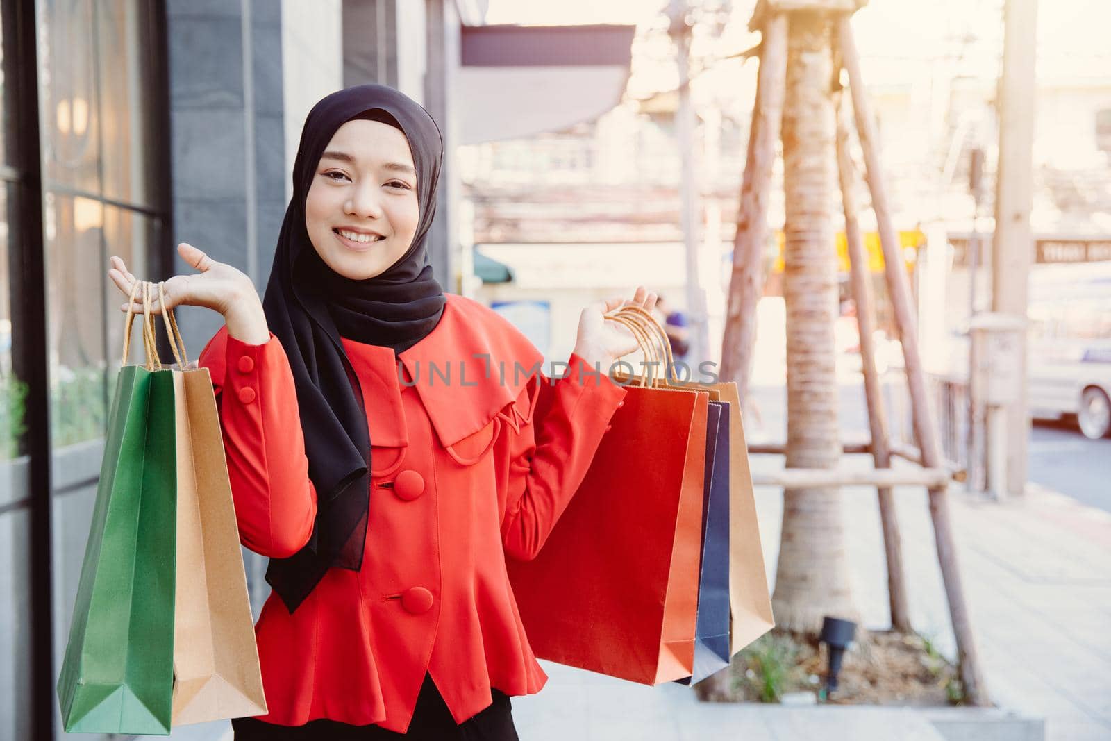 Arab Muslim young woman in veil hijab clothes holding shopping bags at city metro walking street. by qualitystocks