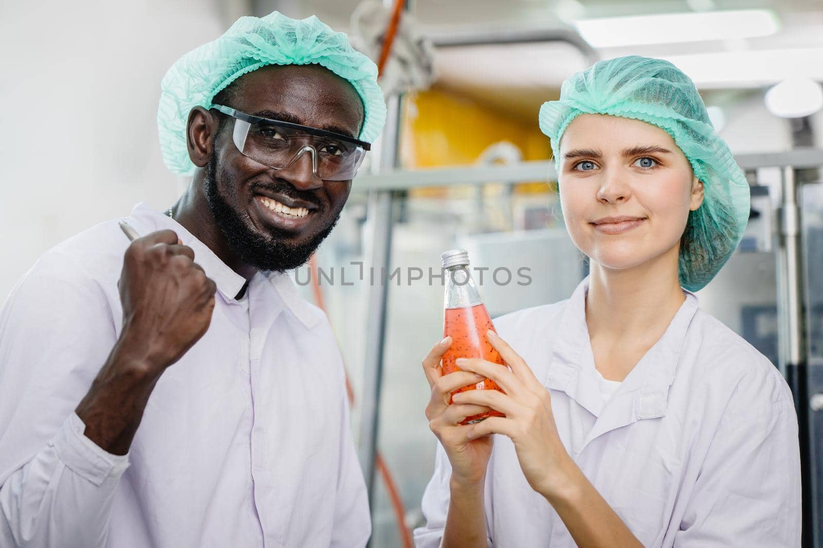 portrait of mix race worker in food and drink factory happy worker together looking camera and smile by qualitystocks