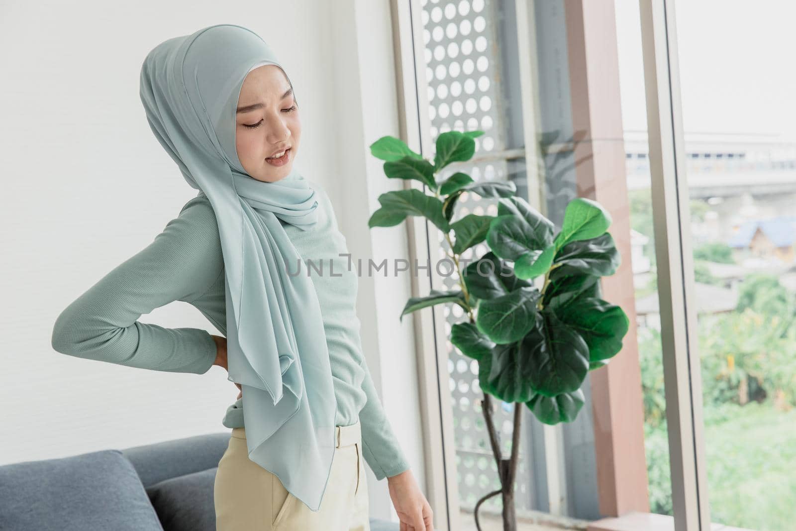 muslim arab women hand at back pain, Waist pain painful expression from office syndrome. by qualitystocks