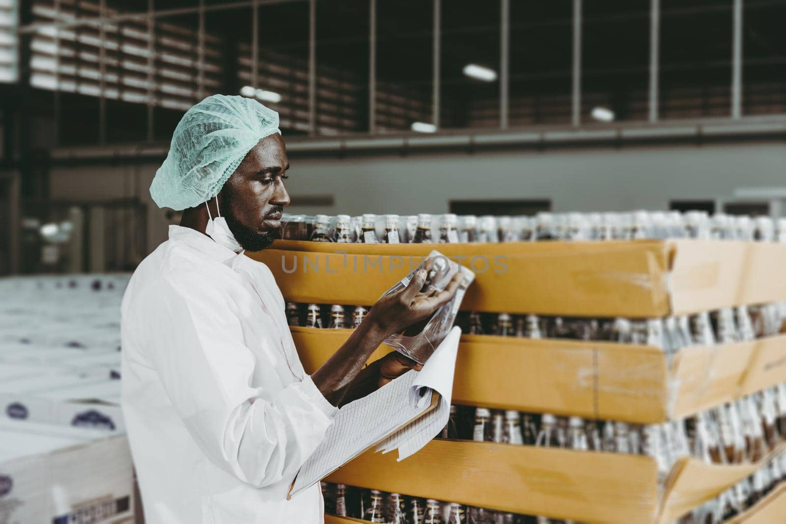 Black African worker working in industry factory products checking inventory stock in the warehouse.