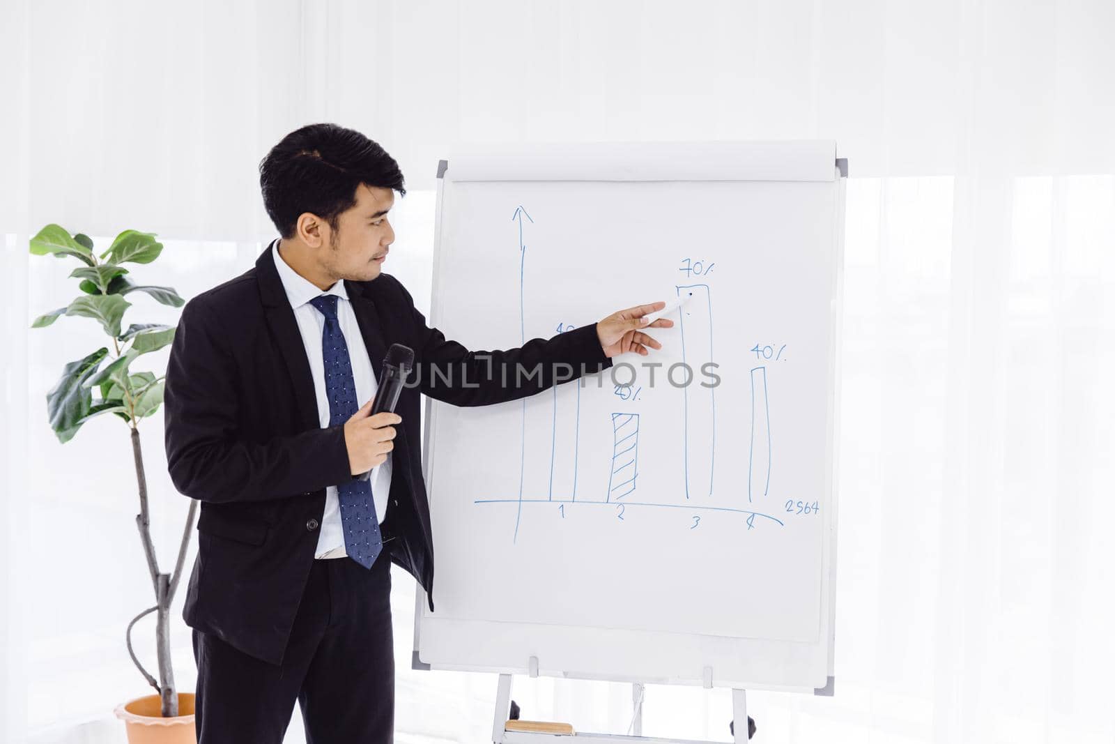 Smart Asian businessman sale presentation with confident in office meeting with better annual sales results good performance. Business seminar lecture training concept.