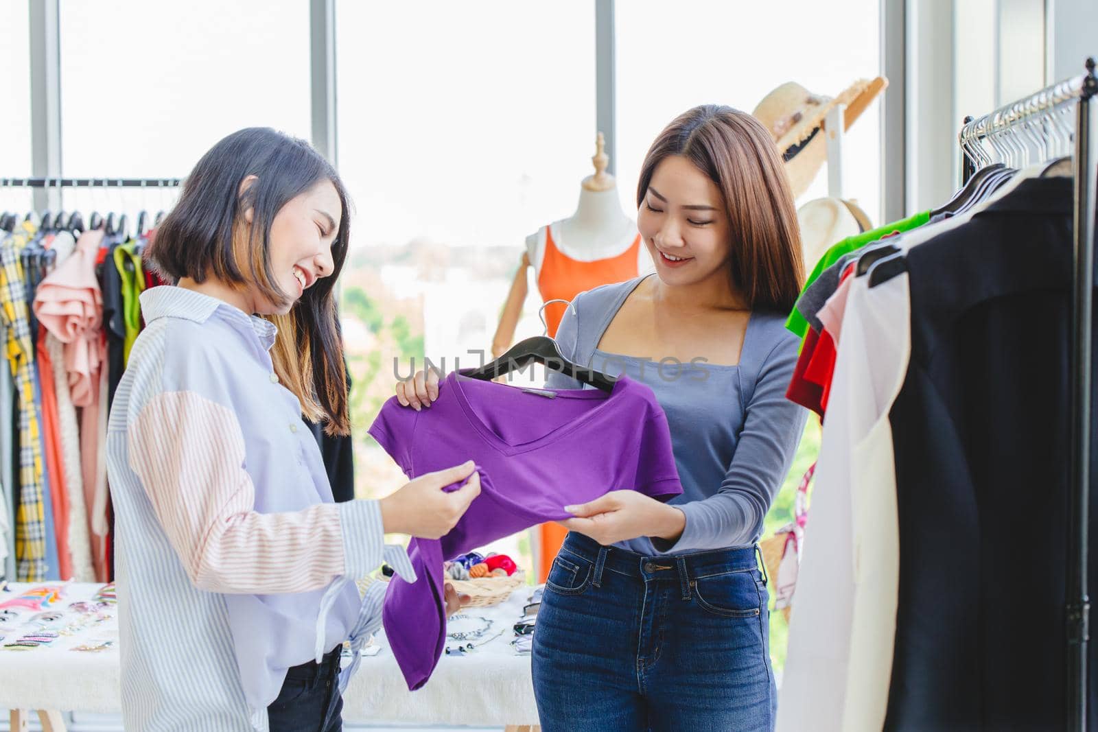 Women customer choosing clothes in fashion shop with business owner care service with happy smile. by qualitystocks