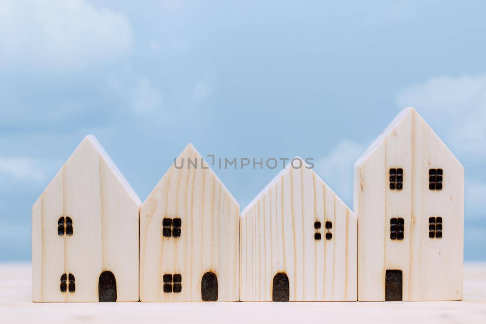 wooden home small model with blue sky for village good house city urban community concept. by qualitystocks