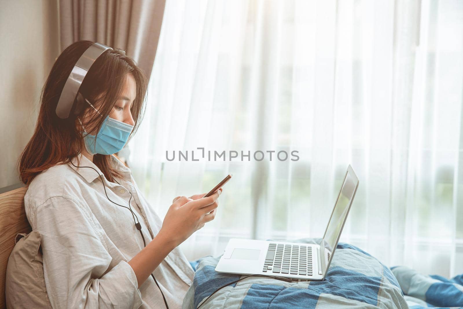 Girl teen covid self quarantine lockdown stay at home enjoy with smartphone internet laptop listening the music. by qualitystocks