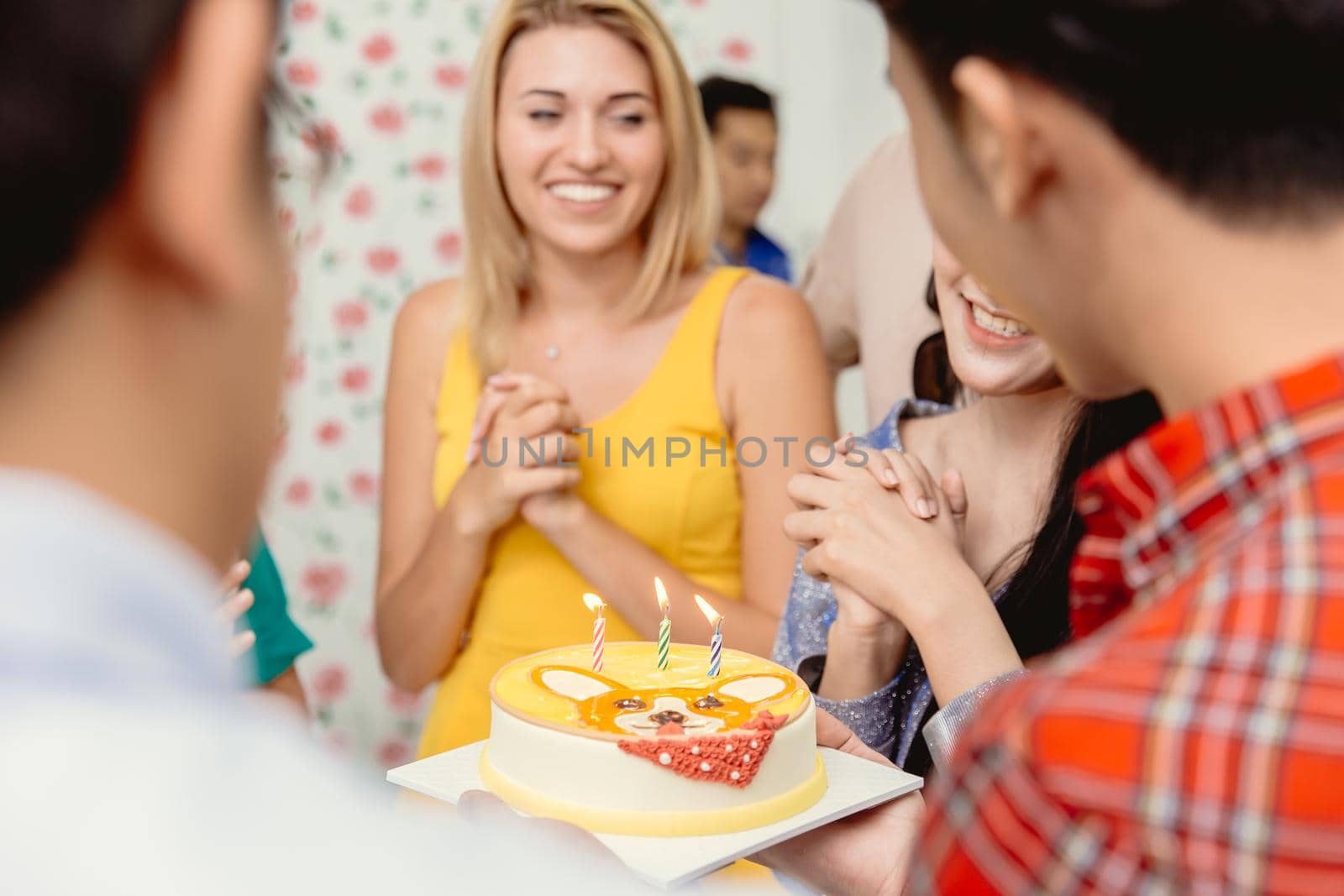 Happiness moment birthday party cake with candle woman and friends enjoy smiling, selective focus at birthday cake candle. by qualitystocks