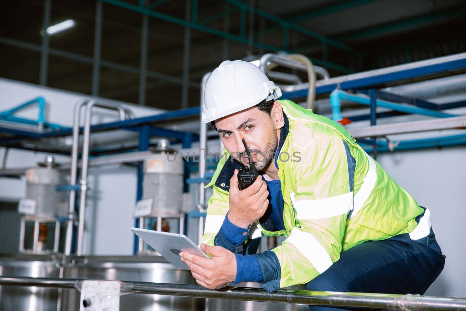 Engineer worker team communication using radio while working in industrial factory.