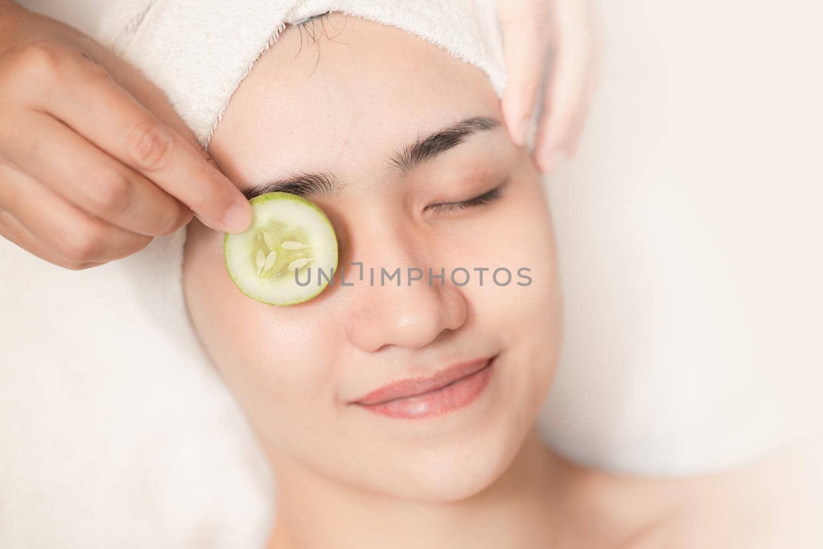 beautiful women facial skin care eyes wrinkle cucumber treatment in spa salon relax happy smile.