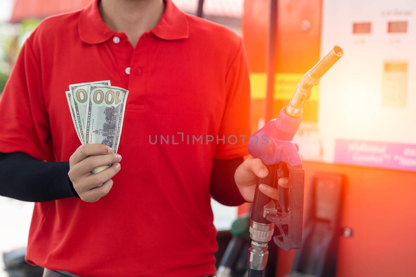 Fuel cost saving concept, staff worker hand holding money cash back at Gas station