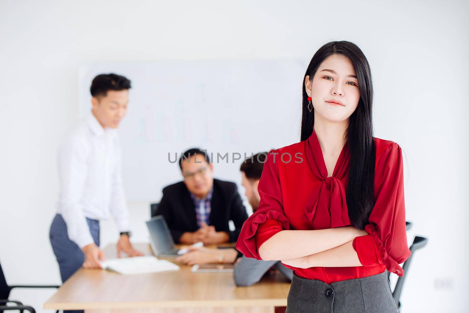 Young Asian business women leader executive standing confident working in office with team. by qualitystocks