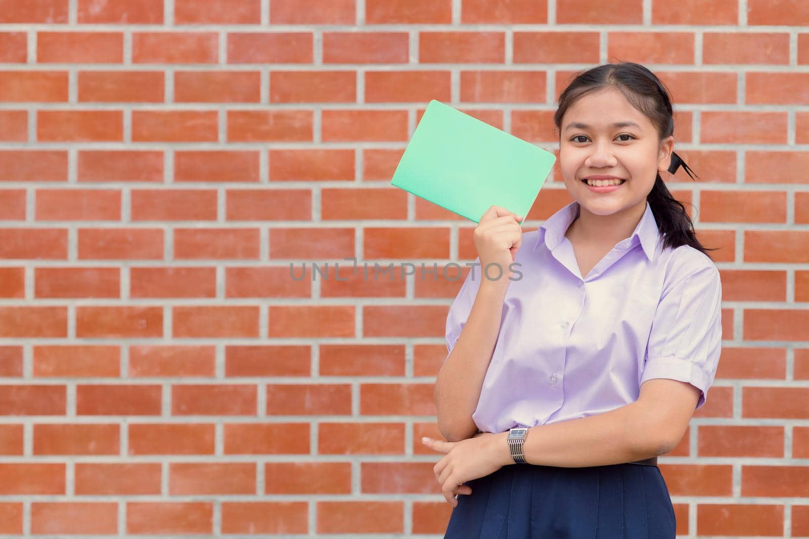 Asian girl teen student uniform happy smiling portrait with book for education back to school concept. by qualitystocks
