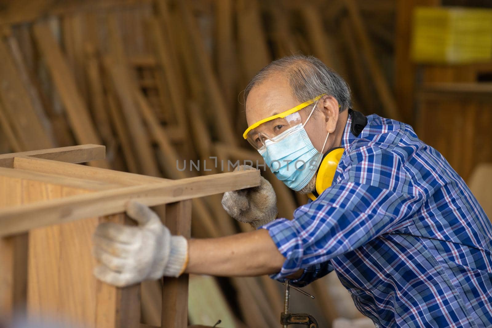 Elder worker wood woodcraft retire hobby for good retirement, Asian male mature professional master of making wooden furniture with face mask protective. by qualitystocks