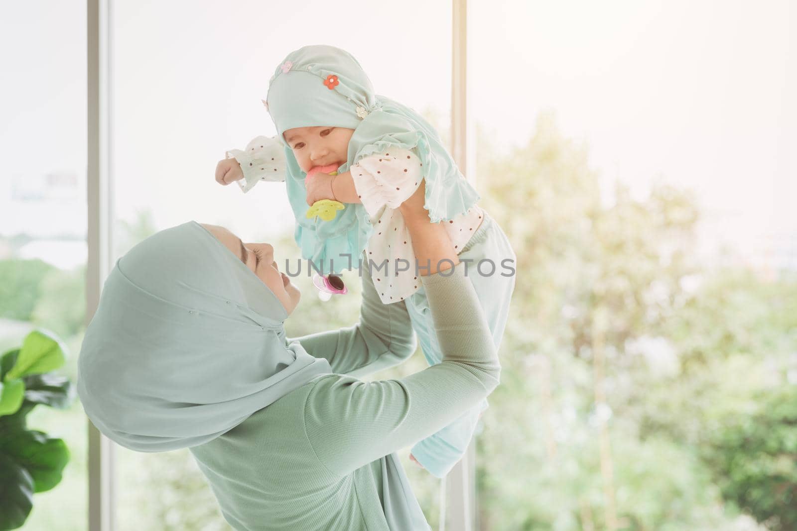 Muslim family or Islam mother with her healthy baby happiness playing together at lovely home. single mom. by qualitystocks