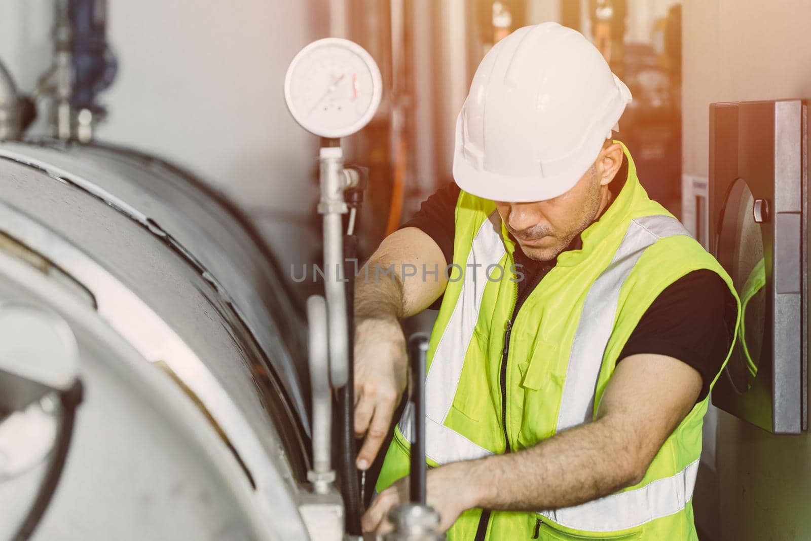 Factory service worker engineer working in factory check maintenance boiler water pump pressure pipe leak in plant. by qualitystocks