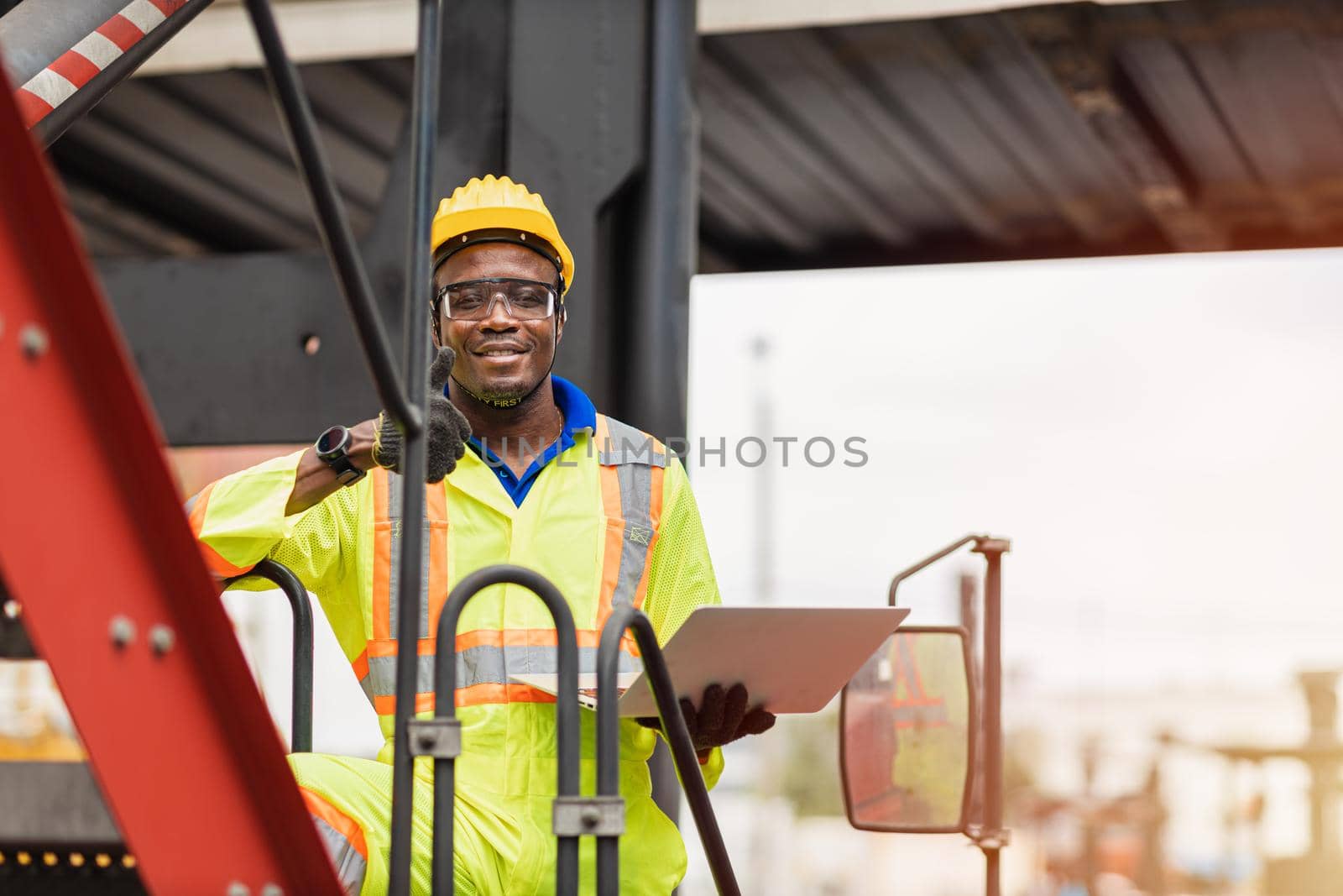 Portrait Black African staff worker happy smile working in cargo crane shipping logistic port. by qualitystocks
