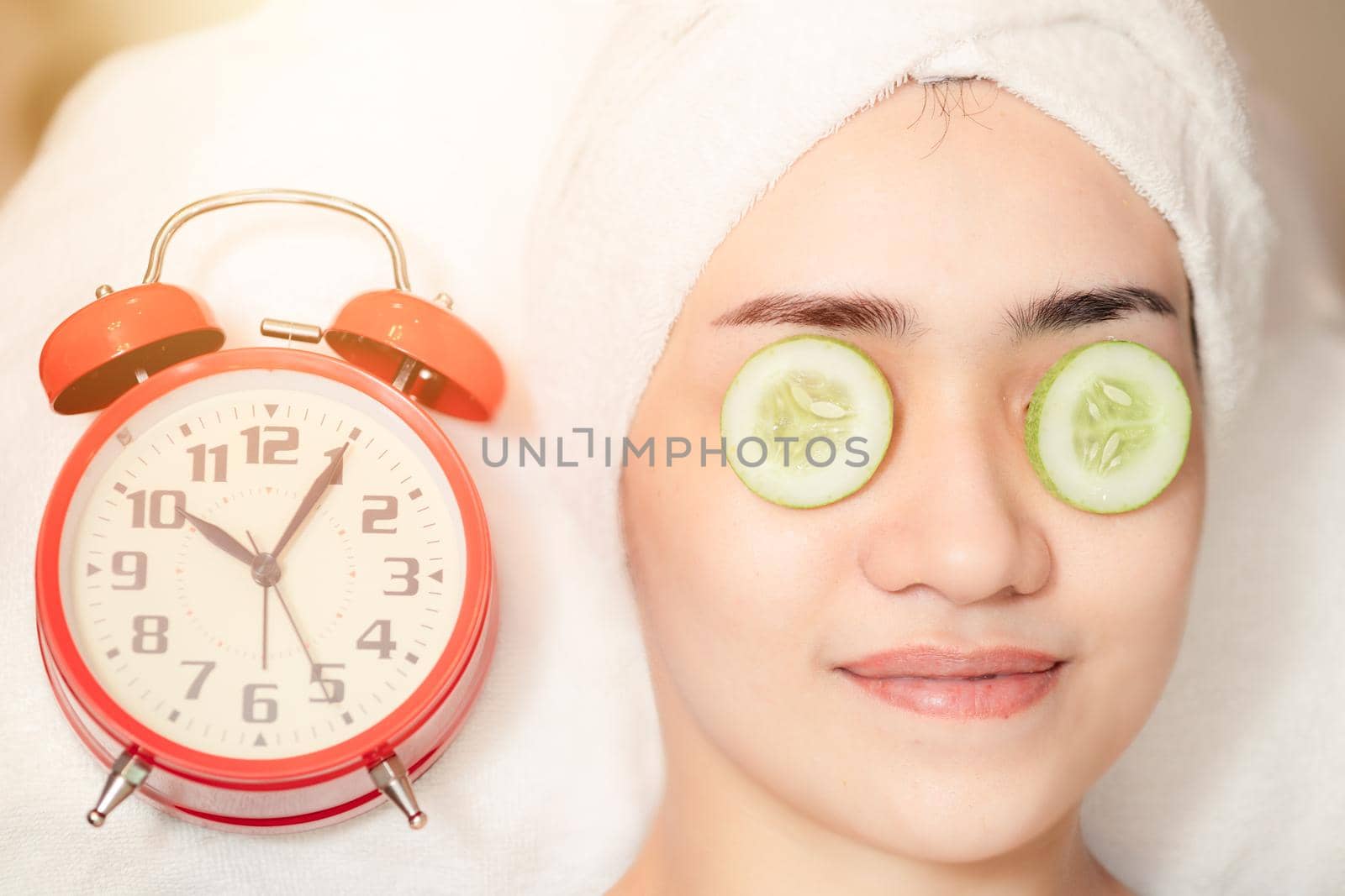 Women facial treatment in spa with time clock. Beauty times reverse to healthy skin to baby face anti aging cosmetic concept.