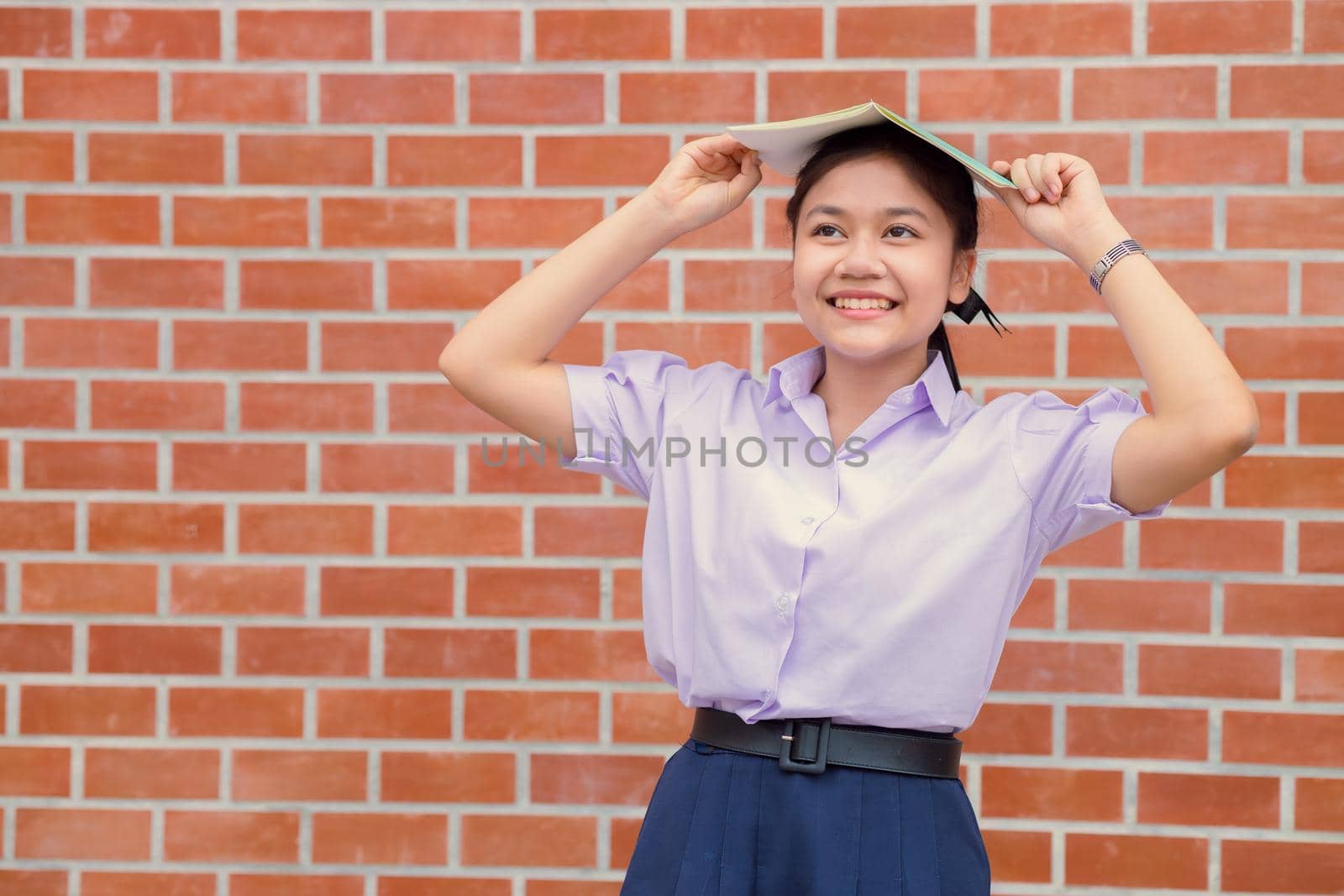 Asian girl teen student uniform happy smile with book for education back to school concept. by qualitystocks