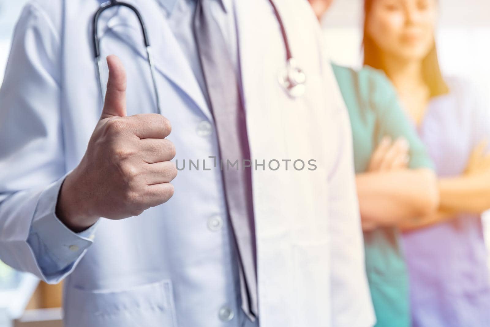 Doctor medical team with hand thumbs up positive sign for good care confirm virus protected service healthcare concept.