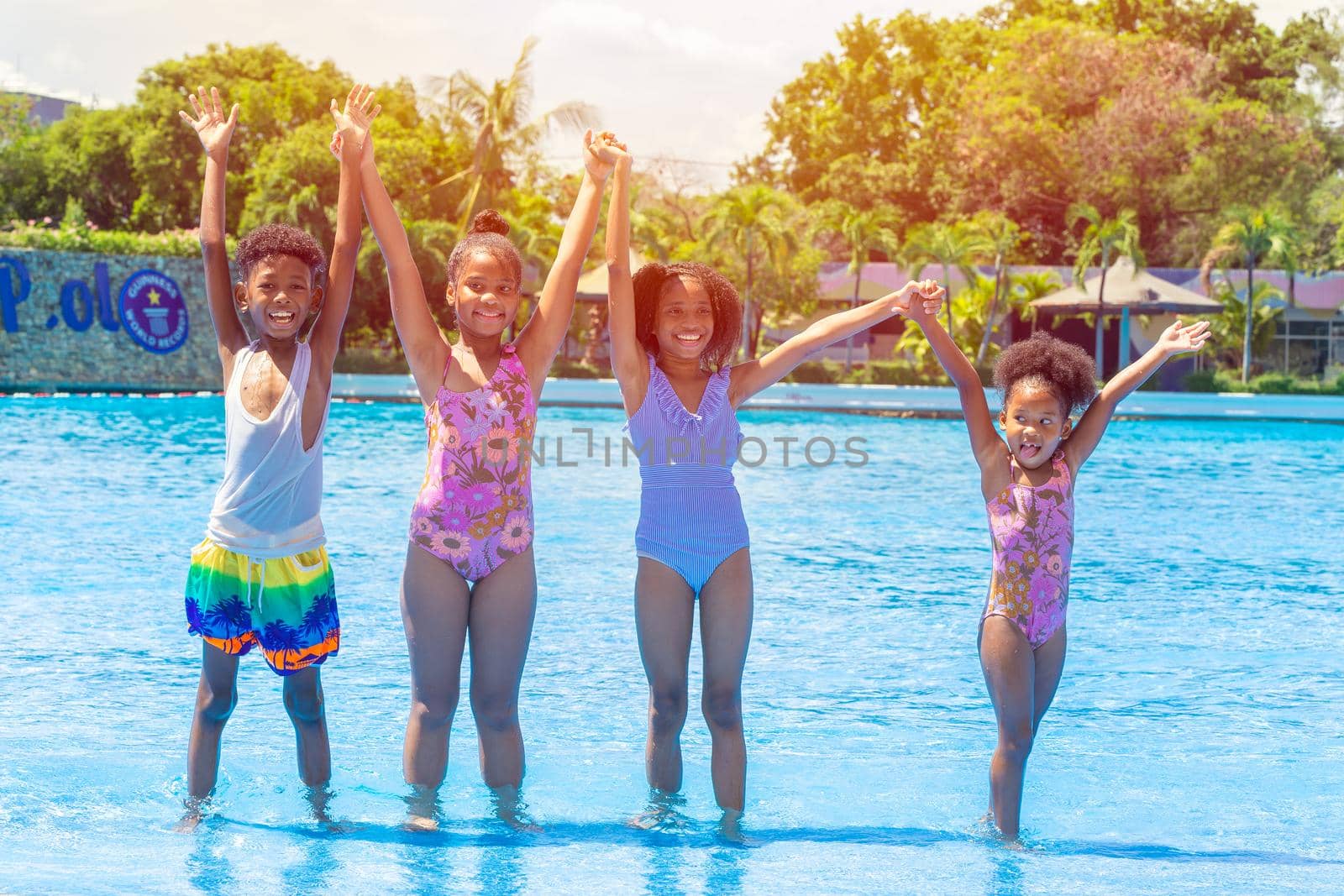 group of black childrens happy playing water pool park outdoor in hot summer season