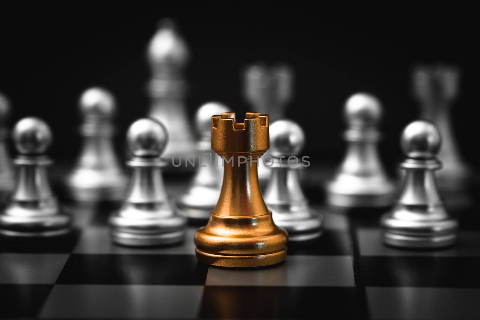 Gold Rook or Castle Tower Chess piece closeup on chess board game. Elite Company leader concept.