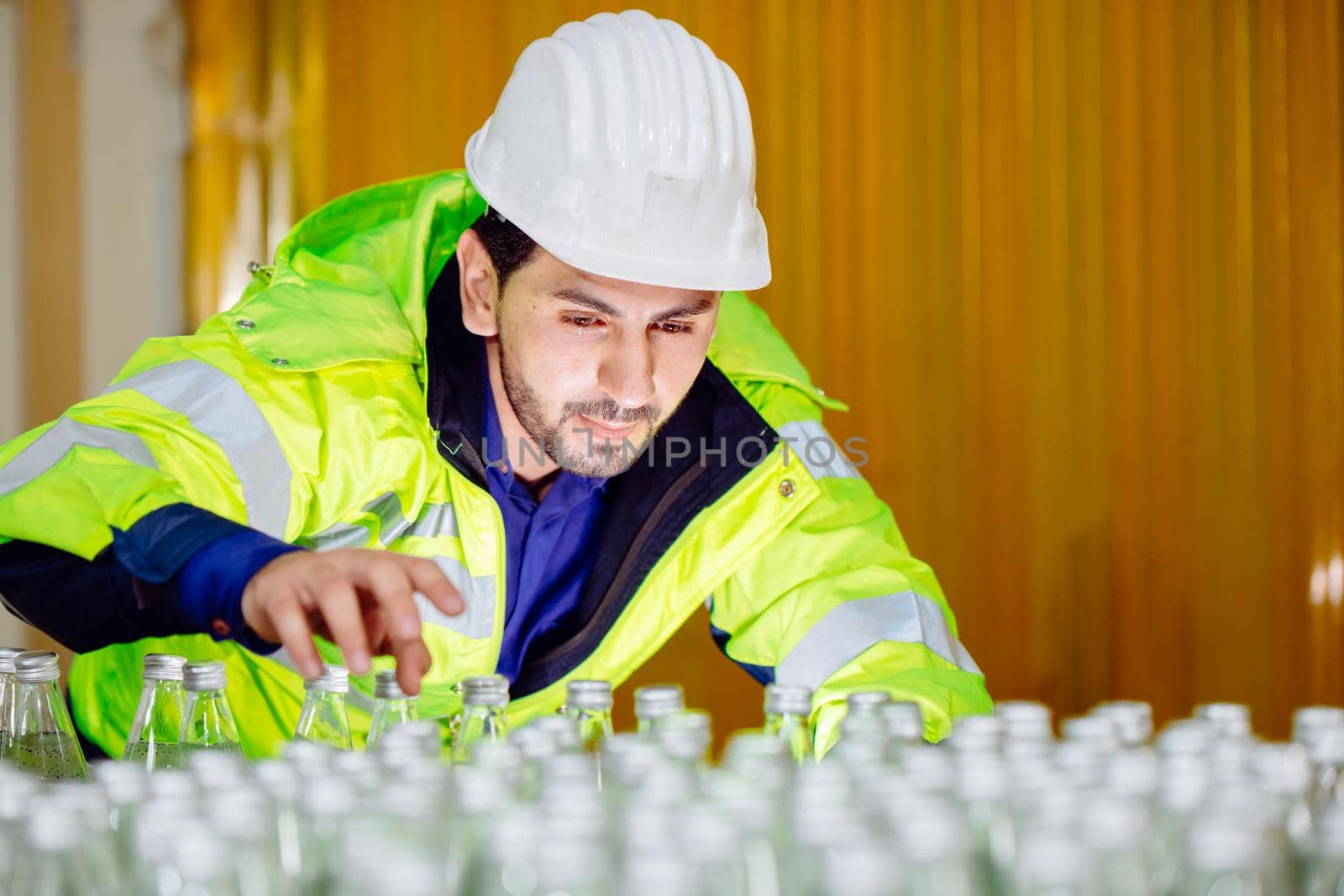 smart Latin engineer worker in factory cargo port logistic warehouse checking count products with safety suit.