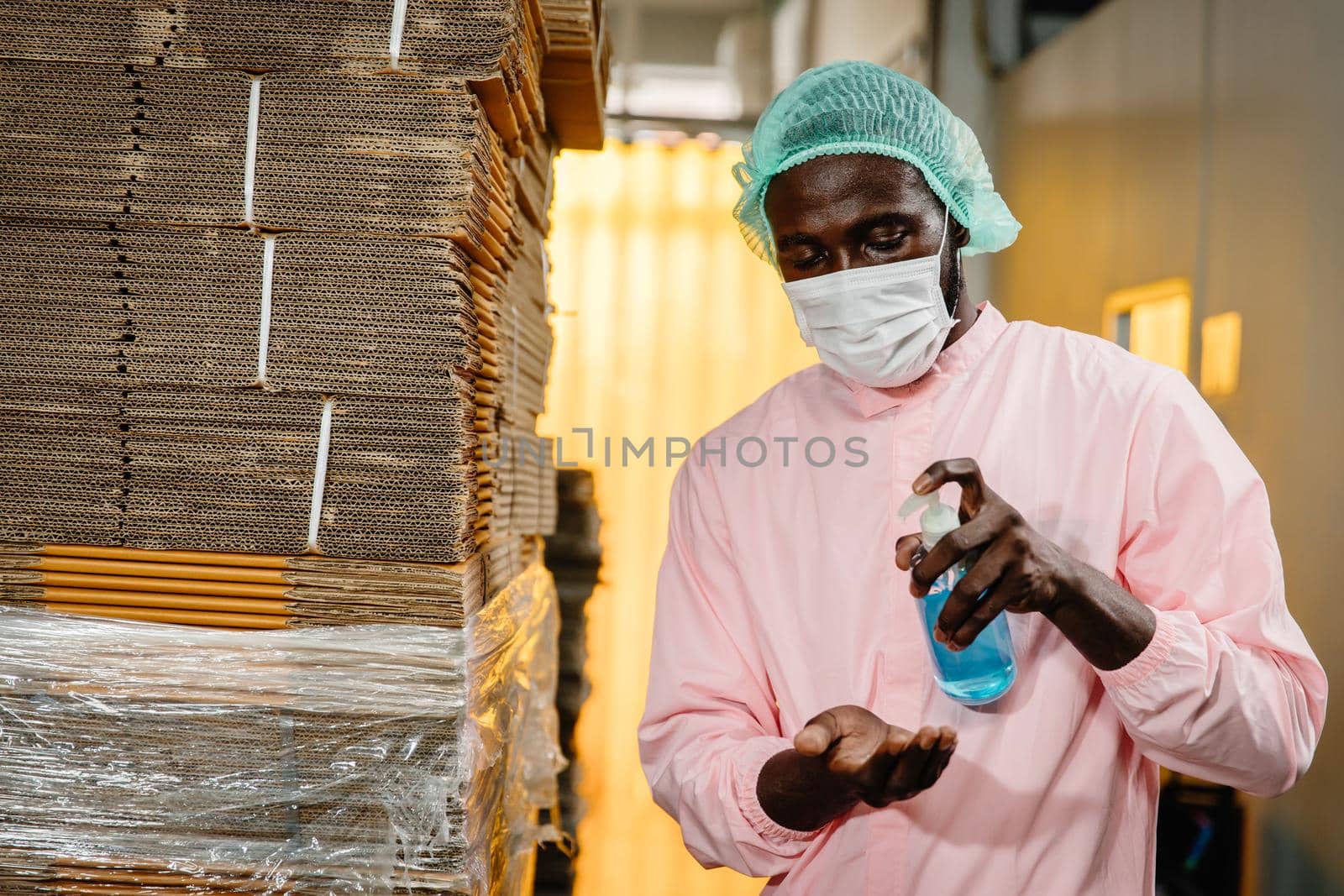 black worker washing clean hands with alcohol gel or antibacterial at factory workplace. hygiene care body sanitizer prevent germs bacteria and covid corona virus infections. by qualitystocks