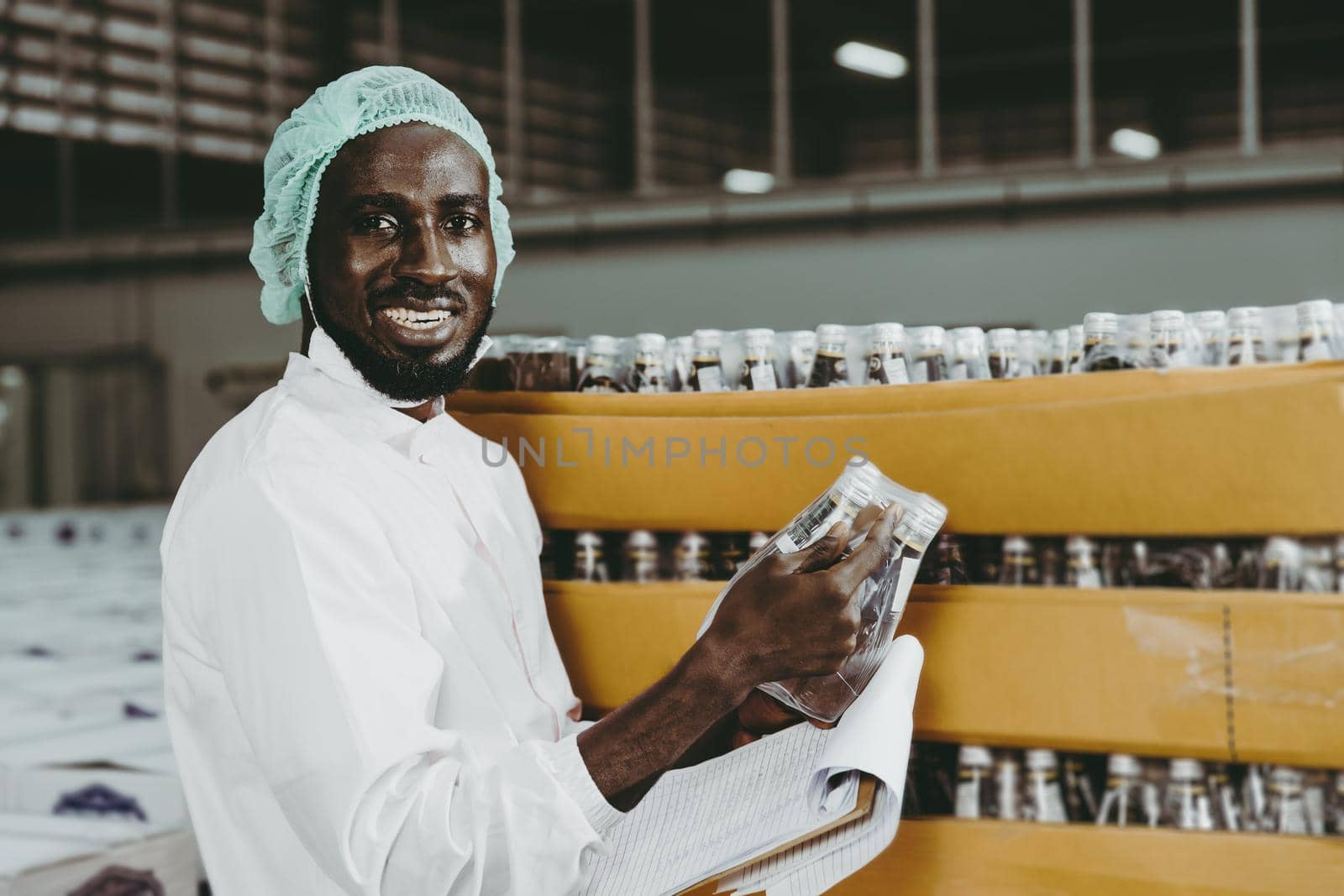 Black African worker working in industry factory products checking inventory stock in the warehouse. portrait looking camera smiling. by qualitystocks