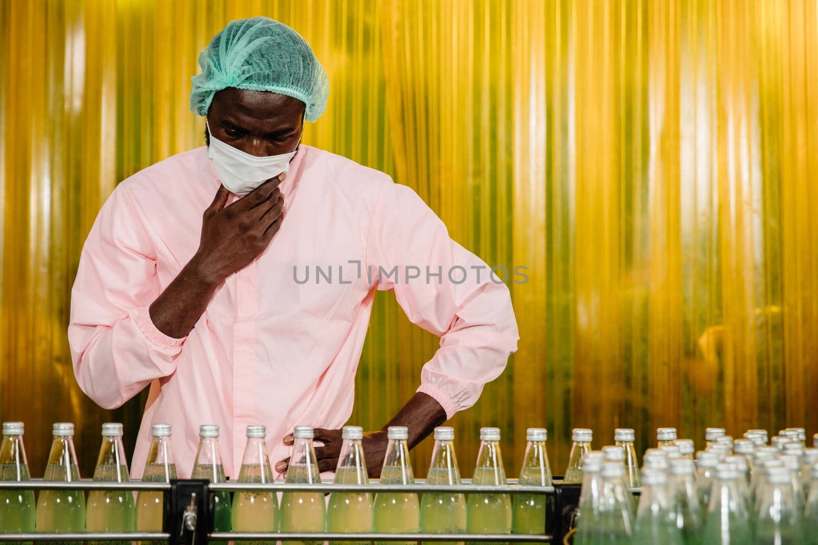 African Black man worker labor working in food and drink industry factory with hygiene work fruit juice production line inspector staff.