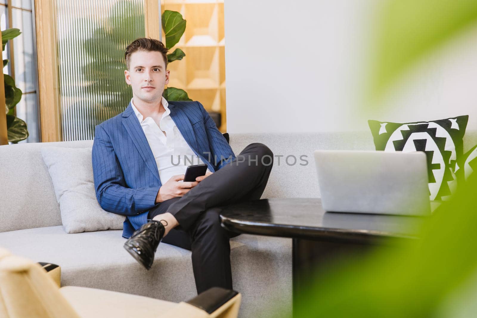 Smart handsome Caucasian businessman sitting relax waiting area in modern office.